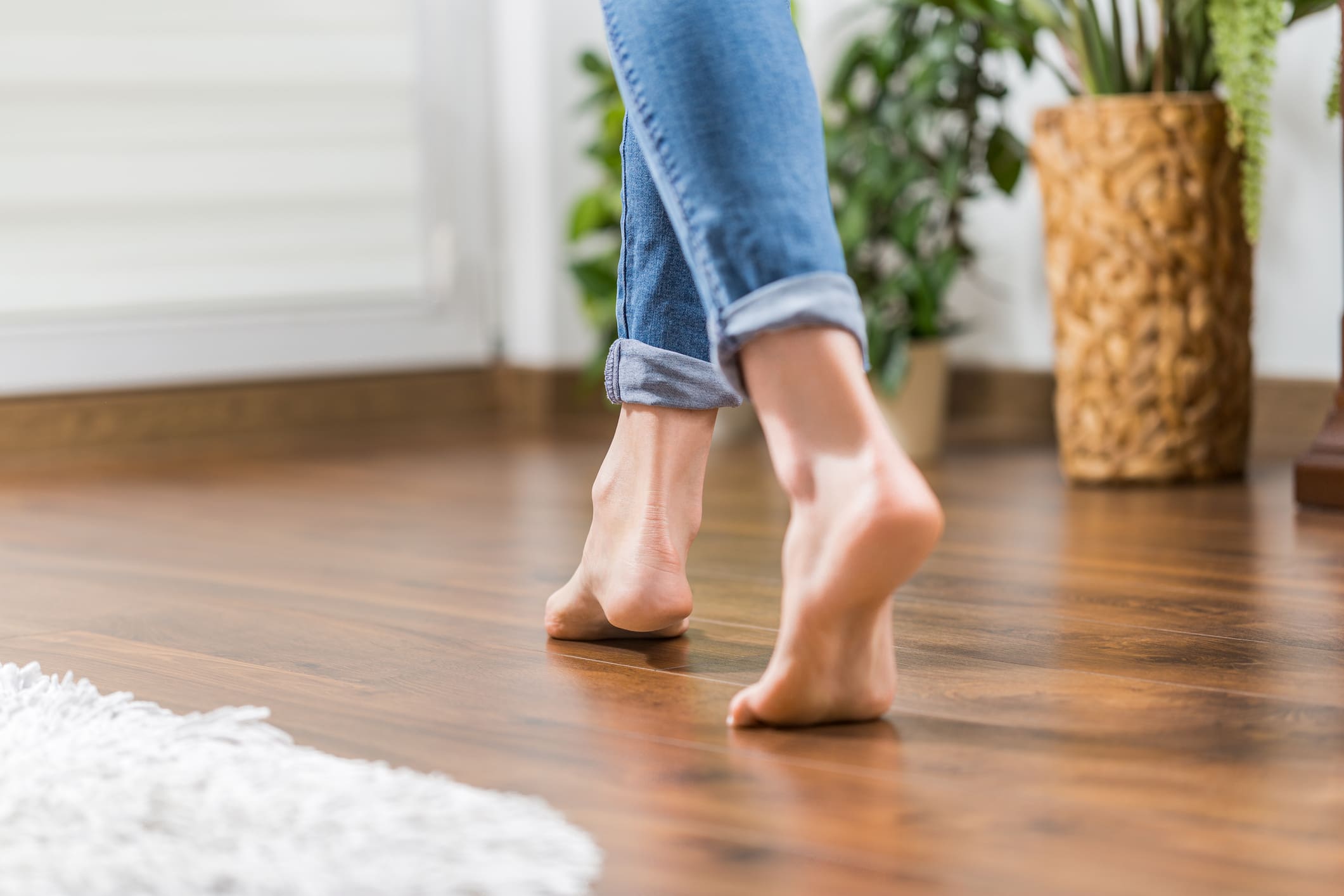 Bare feet walking on wooden floor.